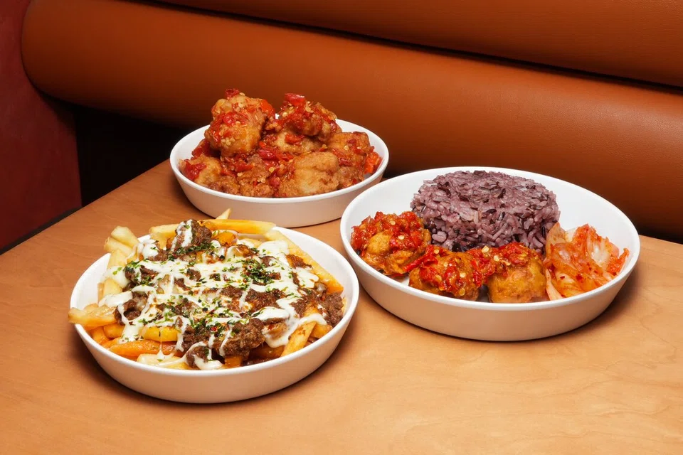(Dari kiri, ikut putaran jam) Hidangan Rendang Bulgogi Beef Loaded Fries, $6.90, Jinjja K-Boneless Chicken with Belado berharga $9.90 dan Belado K-Boneless Chicken with Coconut Rice untuk $10.90 menyatukan hidangan yang menampilkan kepakaran Jinjja Chicken dan Rumah Makan Minang.