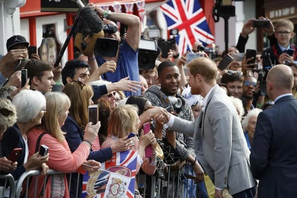 Putera Harry menemui orang ramai di jalan di luar Windsor Castle di Windsor pada 18 Mei 2018, malam perkahwinan dirajanya kepada pelakon Amerika Meghan Markle. 