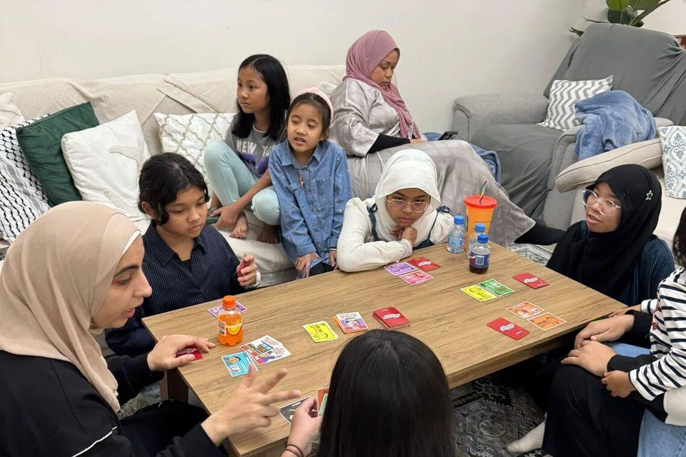 Kanak-kanak Singapura di sana bermain permainan kad, The Singaporean Dream Game, ketika sesi menziarahi di hari keempat Hari Raya Aidilfitri. 