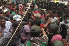 PEGAWAI PEMERINTAH BANYAK MEMBANTU: Selain polis, anggota tentera turut membantu mengawal keamanan ketika penduduk desa di Probolinggo, Jawa Timur, bersesak-sesak mahu mengambil sekilogram daging sempena upacara korban tahun ini. - Foto DARUL AJYAL & SERVICES