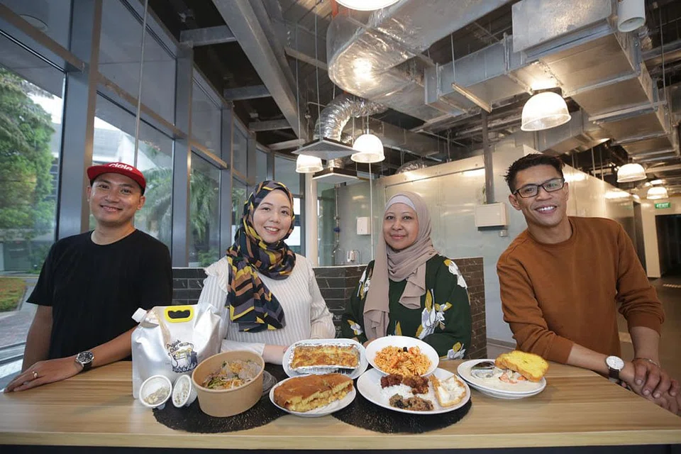 RUANG UNTUK PENIAGA: PengasasKloudwork Pte Ltd (dari kiri) Encik Dzulkifli Ahmad dan Cik Nana Adam, bersama pasukan mereka, Cik Yati Jantan dan Encik Tajjlee Rahim, di ruang dapur mereka di bangunan Sparkle di Science Park Road. - Foto BH oleh TIMOTHY DAVID