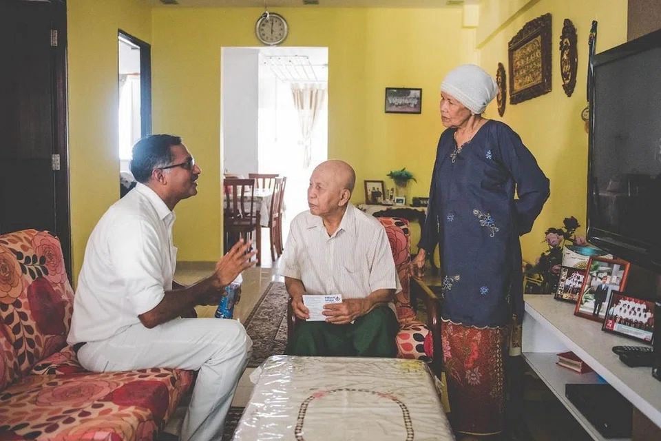 DEKATI PENDUDUK: Semasa sesi melawat rumah penduduk, bakal calon Parti Tindakan Rakyat (PAP) bagi pilihan raya kecil Bukit Batok, Encik K. Muralidharan Pillai (kiri), berpeluang menemui Encik Hamin Amat dan isteri, yang telah menetap di Bukit Batok selama 31 tahun. - Foto FACEBOOK