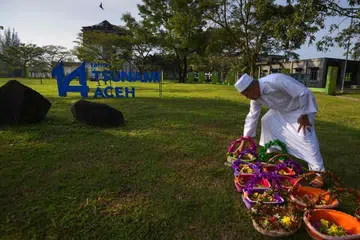 MEMPERINGATI PERISTIWA TSUNAMI: Seorang lelaki membuat persiapan untuk menziarahi kubur mangsa tsunami pada 2004 di Ulee Lheue. 