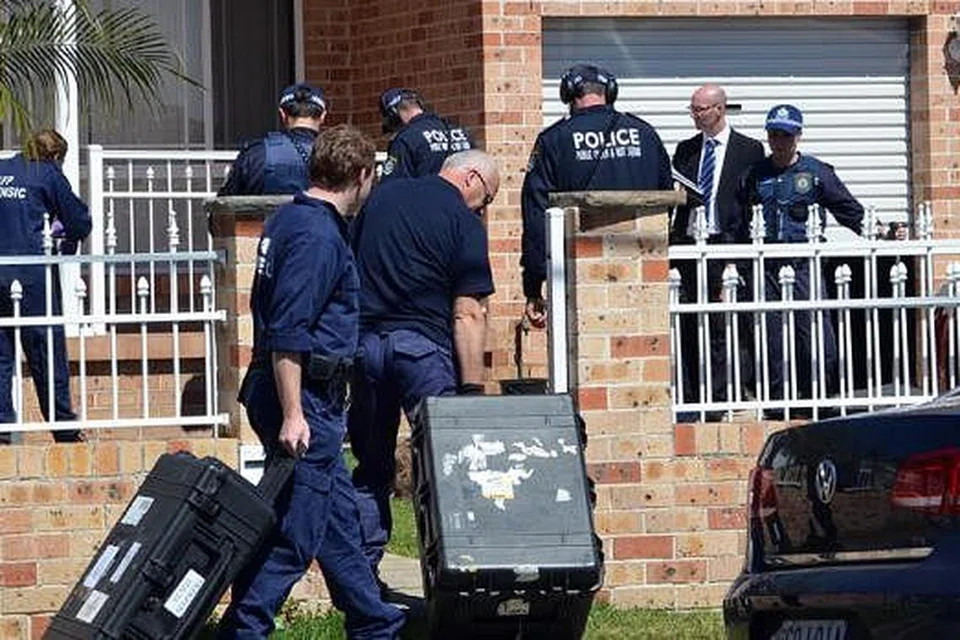 KEDIAMAN DISERBU: Pakar forensik mengumpulkan bukti daripada sebuah ruman di kawasan Guildford, Sydney, semalam. - Foto AFP