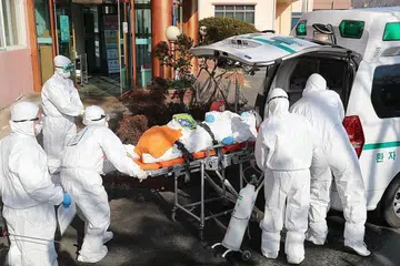 KORONAVIRUS DI KOREA SELATAN: Pekerja perubatan membawa pesakit yang disyaki dijangkiti Covid-19 dari Hospital Daenam Hospital di Cheongdo ke sebuah hospital lain.