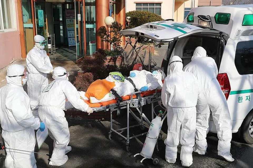 KORONAVIRUS DI KOREA SELATAN: Pekerja perubatan membawa pesakit yang disyaki dijangkiti Covid-19 dari Hospital Daenam Hospital di Cheongdo ke sebuah hospital lain.