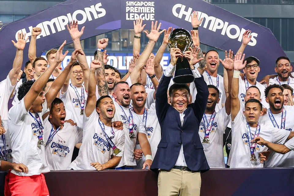 Pemilik Lion City Sailors, Forrest Li (depan), menjulang trofi Liga Perdana Singapura (SPL) semasa sambutan kejayaan pasukan di Our Tampines Hub pada 17 Mei 2026. Mereka kini berdepan cabaran tanpa seorang ketua jurulatih hanya dua minggu sebelum musim bermula.
