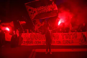 Penunjuk perasaan pro-Palestin memegang suar dan sepanduk ketika membantah tindakan tentera Israel memintas beberapa kapal Flotila Global Sumud yang dalam perjalanan menuju ke Gaza dan memusnahkan sekatan laut Israel, di Bologna, Italy, 2 Oktober 2025