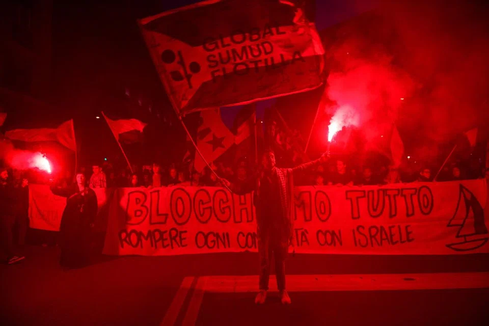 Penunjuk perasaan pro-Palestin memegang suar dan sepanduk ketika membantah tindakan tentera Israel memintas beberapa kapal Flotila Global Sumud yang dalam perjalanan menuju ke Gaza dan memusnahkan sekatan laut Israel, di Bologna, Italy, 2 Oktober 2025