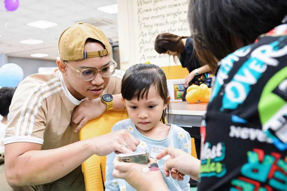 Encik Muhammad Syarifuddin Daud (kiri) bersama anak sulungnya, Irdina Muhammad Syarifuddin (tengah) semasa acara Family PlayDate anjuran Yayasan Mendaki di Sekolah Rendah Fuchun.