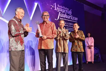 SUMBANGAN DIIKTIRAF: Encik Bahren Shaari (dua dari kiri), menerima Anugerah Jauhari daripada Perdana Menteri Lee Hsien Loong, dengan diiringi Pengerusi Singapore Press Holdings, Dr Lee Boon Yang (dua dari kanan) dan Editor Berita Harian/Berita Minggu, Encik Saat A. Rahman. - Foto BH oleh DESMOND WEE