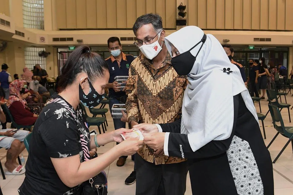 HABUAN RAMADAN: Setiausaha agung Persatuan Muhammadiyah, Cik Roszanah Abdul Salim (bertudung), menyampaikan habuan kepada seorang penerima dalam satu acara Ramadan di Bukit Batok. Bersama mereka ialah Encik Murali Pillai, Anggota Parlimen dan penasihat pertubuhan akar umbi Bukit Batok. - Foto fail