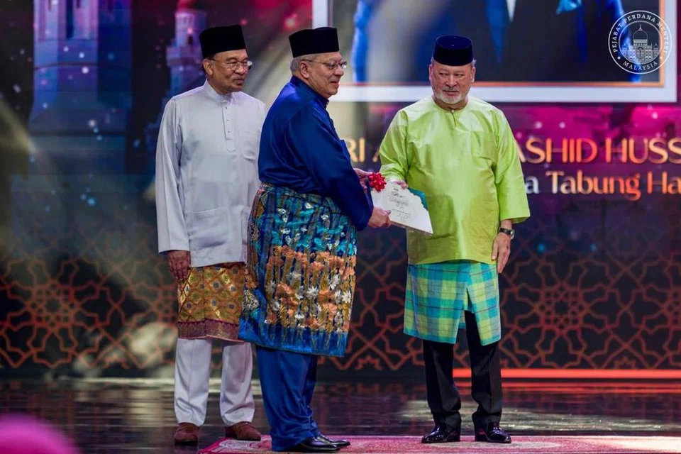 Perdana Menteri Malaysia, Datuk Seri Anwar Ibrahim (kiri) menyaksikan Yang di-Pertuan Agong, Sultan Ibrahim (kanan) menyampaikan anugerah tertinggi iaitu Anugerah Tokoh Perdana Maulidur Rasul kepada Pengerusi Lembaga Tabung Haji (TH) yang juga pengasas RHB Bank, Tan Sri Abdul Rashid Hussain, sempena Sambutan Maulidur Rasul Peringkat Kebangsaan 1447H/2025M di Kuala Lumpur pada 5 September.