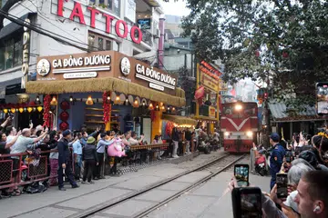 Pelancong memetik gambar dan merakam video kereta api di laluan kereta api di Hanoi, Vietnam, pada 10 Mac 2025.