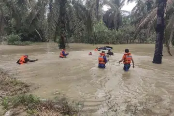 BERTARUNG NYAWA: Pasukan Angkatan Pertahanan Awam Malaysia membantu menyelamatkan empat kakitangan Jabatan Kemajuan Orang Asli yang nyaris lemas dan menarik kenderaan pacuan empat roda yang dihanyutkan arus deras banjir di Kampung Orang Asli Sedohok, Kahang Kluang, Johor, pada 10 Januari.