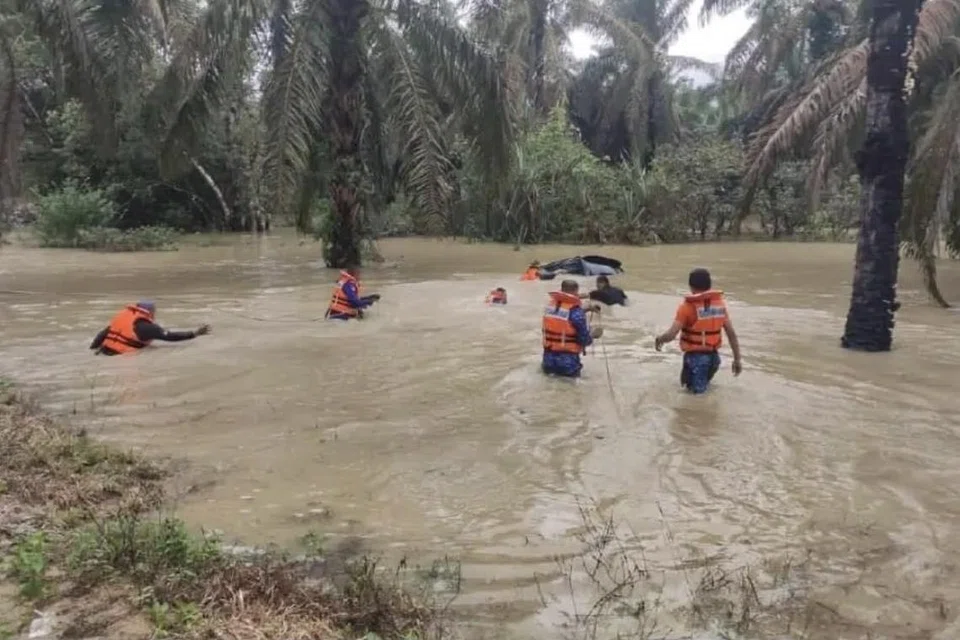 BERTARUNG NYAWA: Pasukan Angkatan Pertahanan Awam Malaysia membantu menyelamatkan empat kakitangan Jabatan Kemajuan Orang Asli yang nyaris lemas dan menarik kenderaan pacuan empat roda yang dihanyutkan arus deras banjir di Kampung Orang Asli Sedohok, Kahang Kluang, Johor, pada 10 Januari.