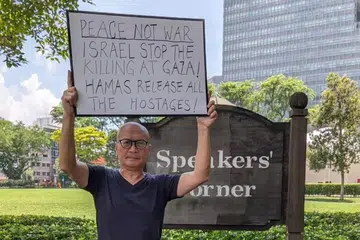 DALAM SIASATAN: Aktivis Gilbert Goh telah memuat naik gambarnya di Sudut Pidato di Hong Lim Park, memegang papan tanda berkaitan konflik Israel-Hamas.