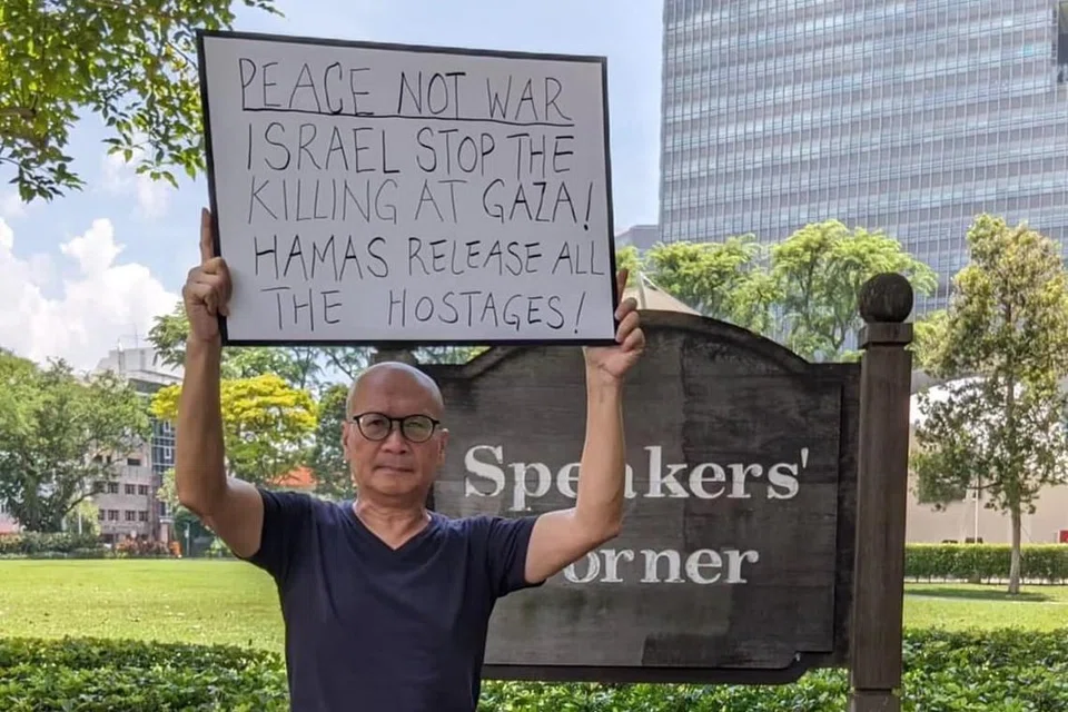 DALAM SIASATAN: Aktivis Gilbert Goh telah memuat naik gambarnya di Sudut Pidato di Hong Lim Park, memegang papan tanda berkaitan konflik Israel-Hamas.