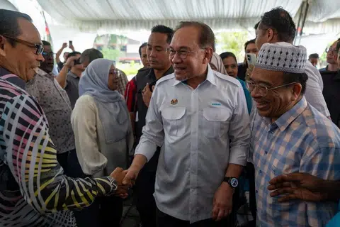 Presiden Parti Keadilan Rakyat (PKR), Datuk Seri Anwar Ibrahim (dua dari kanan), beramah mesra dengan ahli parti di Cabang Langkawi, Kedah, selepas merasmikan pejabat PKR cabang itu pada 19 Mei.