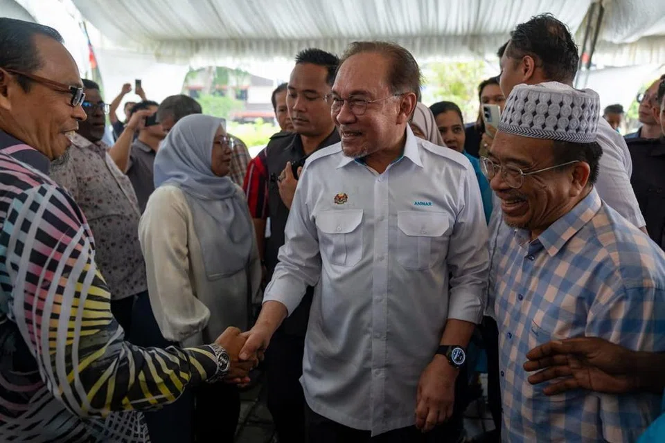 Presiden Parti Keadilan Rakyat (PKR), Datuk Seri Anwar Ibrahim (dua dari kanan), beramah mesra dengan ahli parti di Cabang Langkawi, Kedah, selepas merasmikan pejabat PKR cabang itu pada 19 Mei.