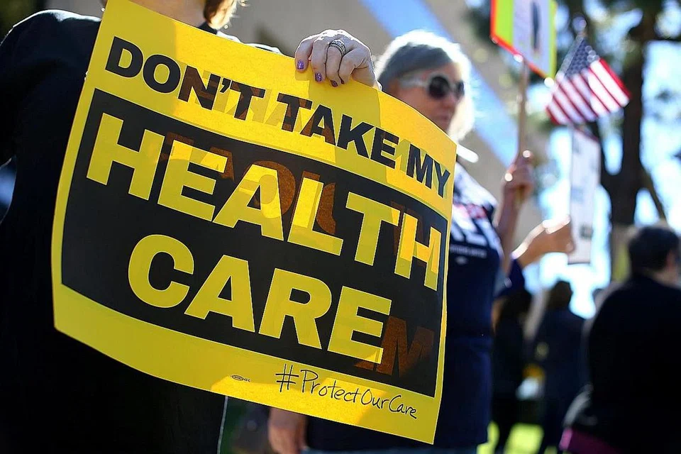 BANTAHAN PELAN INSURANS BARU: Penunjuk perasaan yang membantah tindakan menarik balik pelan insurans Obamacare mengadakan bantahan di luar pejabat ahli kongres Republikan, Encik Darryl Issa, di Vista, California, semalam. - Foto REUTERS