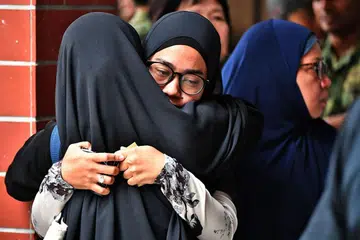 MENAHAN HIBA: Isteri Allahyarham, Cik Norsidah Kamilan, (tengah dan berkaca mata), tidak dapat menahan sebak semalam. - Foto BH oleh LIM YAOHUI