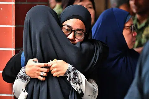 MENAHAN HIBA: Isteri Allahyarham, Cik Norsidah Kamilan, (tengah dan berkaca mata), tidak dapat menahan sebak semalam. - Foto BH oleh LIM YAOHUI