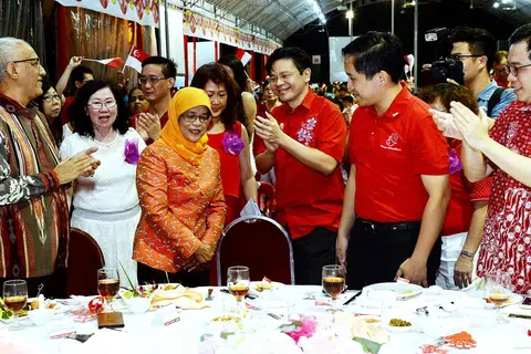 SOKONGAN PADU: Cik Halimah mendapat tepukan gemuruh selepas mengumumkan akan bertanding dalam Pilihan Raya Presiden malam tadi. Turut bersama beliau ialah suaminya, Encik Mohammed Abdullah Alhabshee (kiri) dan AP-AP GRC Marsiling-Yew Tee lain termasuk (dari kanan) Encik Ong Teng Koon, Encik Alex Yam dan Encik Lawrence Wong. - Foto KHALID BABA