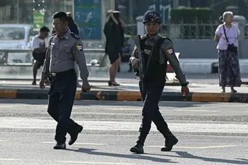 Anggota polis meronda di sebuah jalan semasa fasa pertama pilihan raya umum Myanmar di Yangon pada 28 Disember 2025.