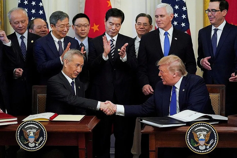 PERSETUJUAN AWAL: Naib Perdana Menteri China Liu He dan Presiden Amerika Donald Trump berjabat tangan selepas menandatangani perjanjian perdagangan tahap pertama antara dua negara itu di Rumah Putih kelmarin. - Foto REUTERS