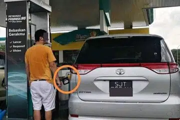 Pemandu kenderaan berdaftar Singapura dilihat mengisi minyak dengan petrol RON95 (pam kuning).
