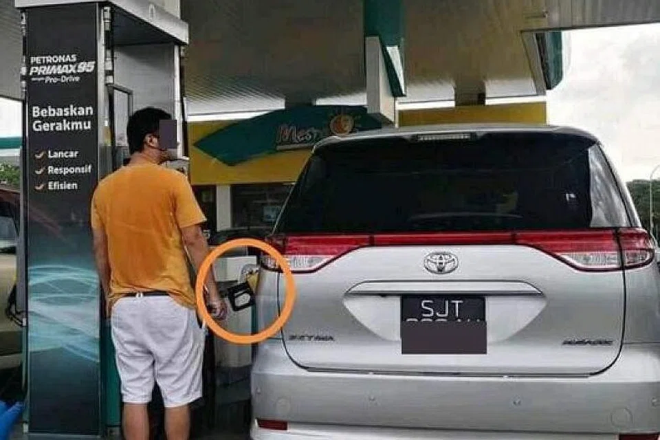 Pemandu kenderaan berdaftar Singapura dilihat mengisi minyak dengan petrol RON95 (pam kuning).
