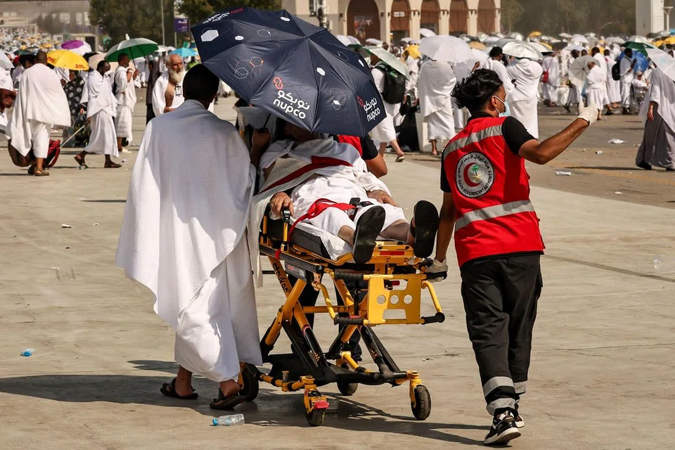 Anggota pasukan perubatan memindahkan seorang jemaah haji yang terjejas oleh bahang panas di kawasan Arafah pada 15 Jun 2024.