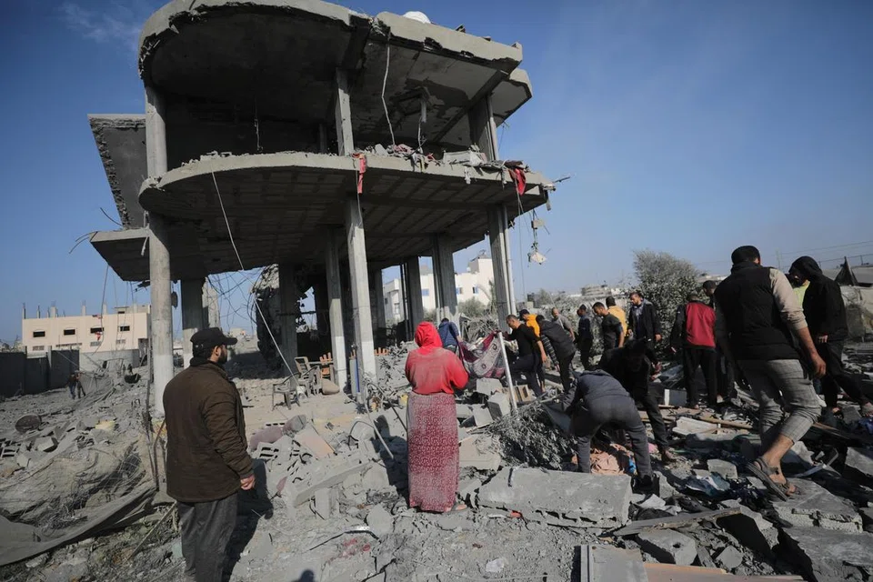 MASIH BERGOLAK: Para penduduk Palestin berusaha mencari mereka yang terselamat selepas pengeboman Israel di kawasan sekitar kem pelarian Khan Younis, selatan Gaza, pada 31 Disember.