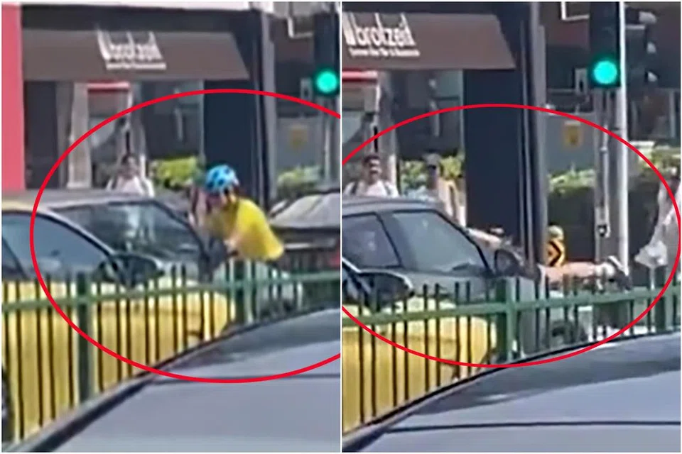 PERTENGKARAN: Seorang wanita penunggang basikal berpaut di atas bonet kereta. 