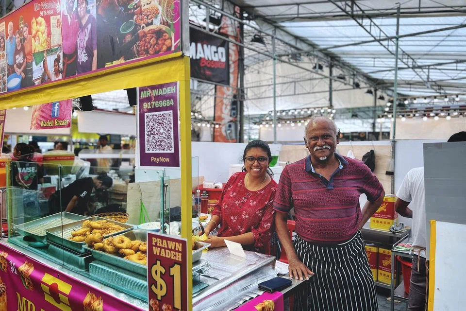 Pemilik Mr Wadeh, Encik Raj Govin (kanan) bersama anaknya Cik Anita (kiri) di bazar Hari Raya Geylang Serai.