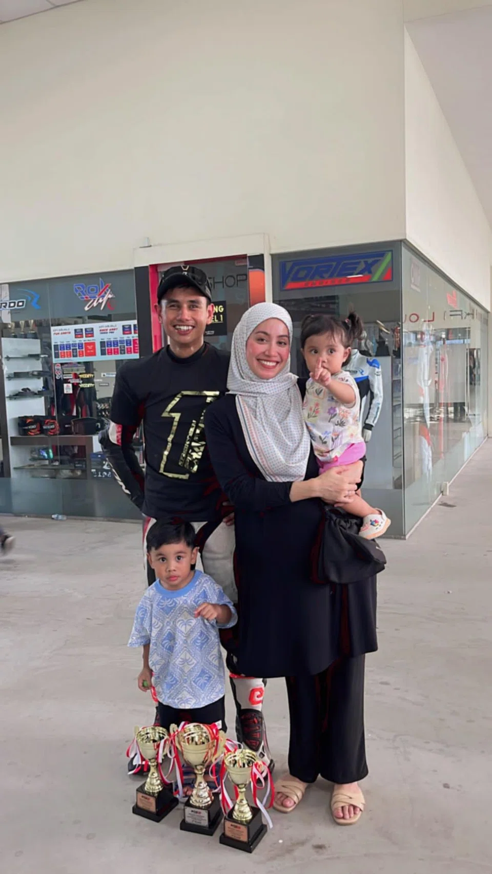 Pelumba motosikal, Muhd Jazil Juraimi (kanan), bersama isteri, Cik Hurulhuda Mustafa dan dua anaknya, Muhammad ‘Aakif Muhammad Jazil dan Naila Inaya Muhammad Jazil (didukung). Anak ketiganya, Muhammad Afif Muhammad Jazil tiada di dalam gambar. Mereka hadir untuk menyokongnya di Kejohanan Motor Sports Singapore (MSS) Kebangsaan pada 2023.