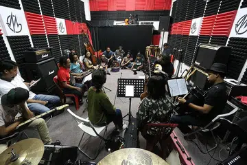SESI LATIHAN: Pemuzik berbincang dalam sesi latihan 'Gala Gemadah', konsert yang akan menggabung 12 kumpulan muzik tradisional Singapura pada 31 Mac ini di Teater Terbuka Esplanade. - Foto GEMADAH