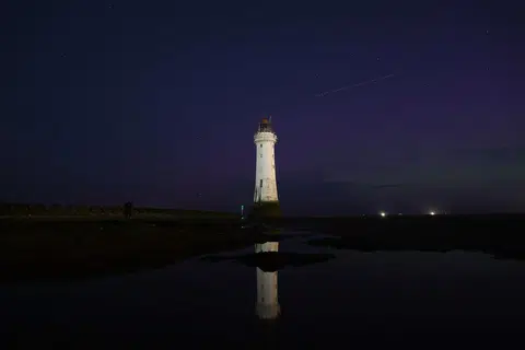 Aurora borealis boleh dilihat sementara meteor melintasi New Brighton Lighthouse di New Brighton, Britain, pada 13 Ogos 2024.
