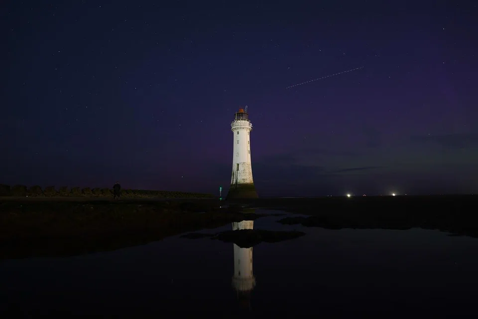 Aurora borealis boleh dilihat sementara meteor melintasi New Brighton Lighthouse di New Brighton, Britain, pada 13 Ogos 2024.