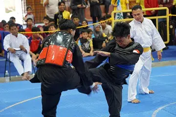 TUNJUK TARING: Ahmad Hanin (kanan) dari Singapura beraksi ketika menentang Muhammad Adam daripada pasukan Kedah Fighter dalam pusingan saringan Tanding Putera D semalam. - Foto PERSEKUTUAN SILAT SINGAPURA