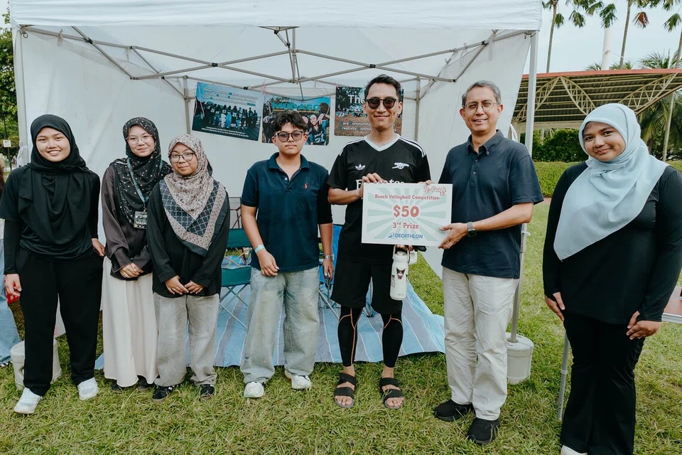 (Dari kiri) Nurul Hudah, 16 tahun; Nur Sophia Mohamed Sophian, 16 tahun; Nur Jazeera Abdullah, 14 tahun; Iman Hakym Nazrie, 15 tahun; dan Encik Abdul Qayyum Sarip, 35 tahun, menerima hadiah tempat ketiga daripada Pemangku Menteri Bertanggungjawab bagi Ehwal Masyarakat Islam merangkap Menteri Negara Kanan (Ehwal Dalam Negeri), Profesor Madya Dr Muhammad Faishal Ibrahim (dua dari kanan); dan Ketua Pegawai Eksekutif (CEO) yang juga Pengasas bersama MudaSG, Cik Sherlita Almeyra Sherhan (kanan) dalam pertandingan bola tampar. 