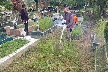 SATU BENTUK SUMBANGAN: Encik Ramli (kanan) bersama anggota Reforming Support Group lain membersihkan tanah perkuburan di Pusara Abadi baru-baru ini. - Foto ihsan RAMLI ABDULLAH
