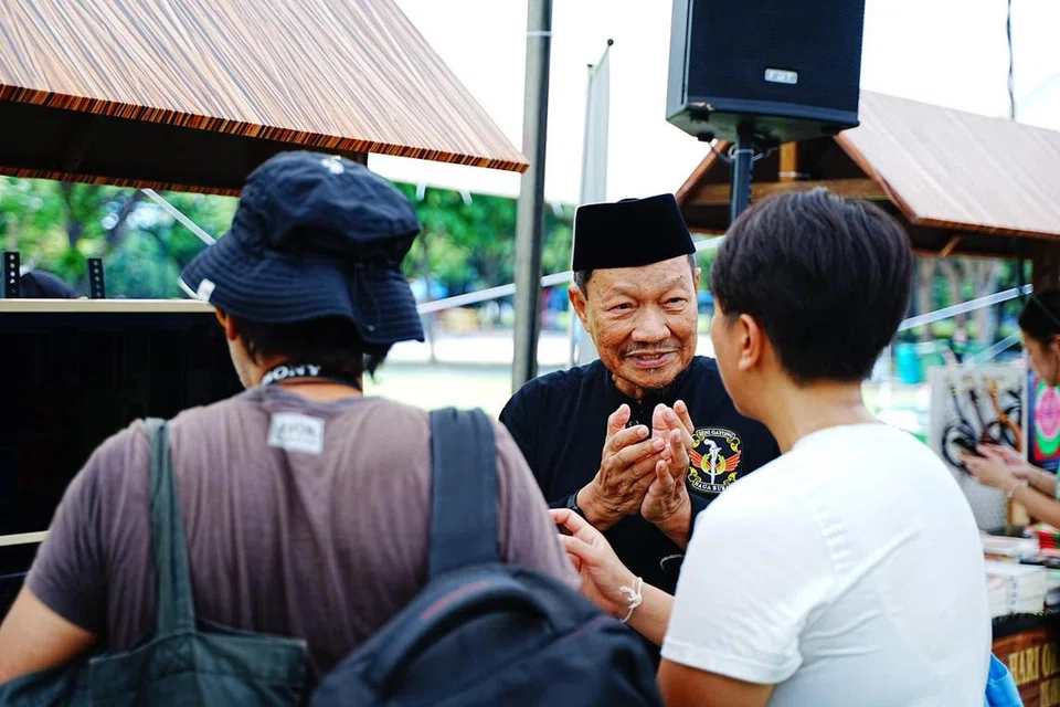 Encik Abdullah Hussain (tengah), menjelaskan mengenai Seni Silat Gayong kepada pengunjung ketika Hari Orang Pulau pada 14 Jun di reruainya.