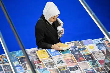 Seorang pengunjung membelek buku-buku di pameran Pesta Buku Antarabangsa Kuwait ke-47 di Bandaraya Kuwait pada 20 November 2024. (gambar hiasan).