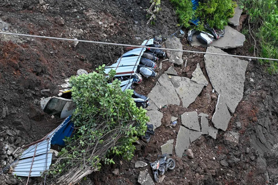 TANAH RUNTUH: Kejadian tanah runtuh akibat hujan lebat menyebabkan kenderaan dihempap struktur binaan di tapak pembinaan perumahan.