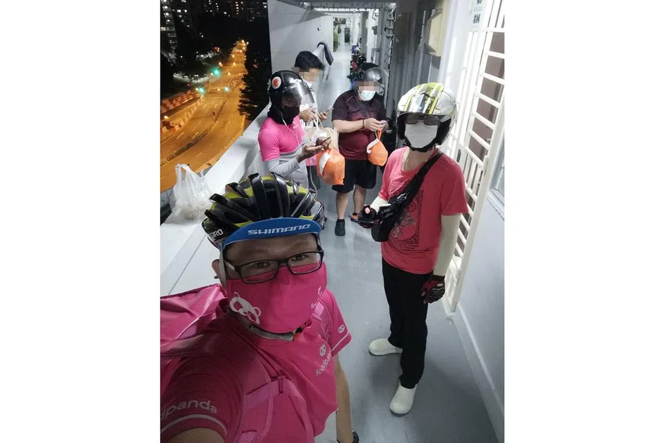 PESANAN PALSU: Encik Mr C.S. (depan) dengan empat lagi penghantar makanan Foodpanda di luar sebuah flat HDB di Ang Mo Kio. Polis sedang menyiasat kes beberapa penghuni di satu alamat di kawasan itu yang mendakwa telah dihantar makanan yang tidak ditempah. - Foto ihsan C.S.