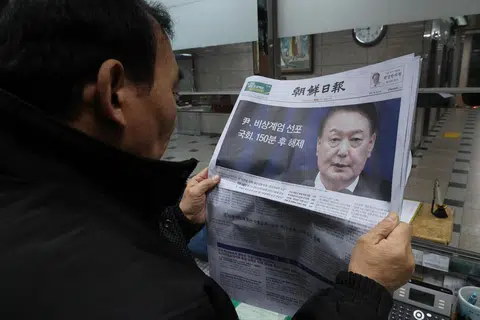 Seorang lelaki membaca akhbar yang melaporkan pengumuman Presiden Korea Selatan, Encik Yoon Suk Yeol, untuk menarik balik undang-undang tentera di negara itu pada 4 Disember. Keputusan itu dibuat hanya beberapa jam selepas Dewan Perhimpunan Kebangsaan sebulat suara meluluskan resolusi mendesak presiden berbuat demikian susulan sesi pleno darurat.