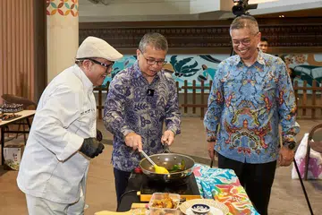 SELERA WARISAN: (Dari kiri) Cef Mel Dean menunjukkan lauk-pauk Melayu kepada Menteri Kebudayaan, Masyarakat dan Belia, Encik Edwin Tong, dan Pengerusi Yayasan Warisan Melayu, Dr Norshahril Saat, semasa Hari Warisan di Wisma Geylang Serai pada 20 Januari.