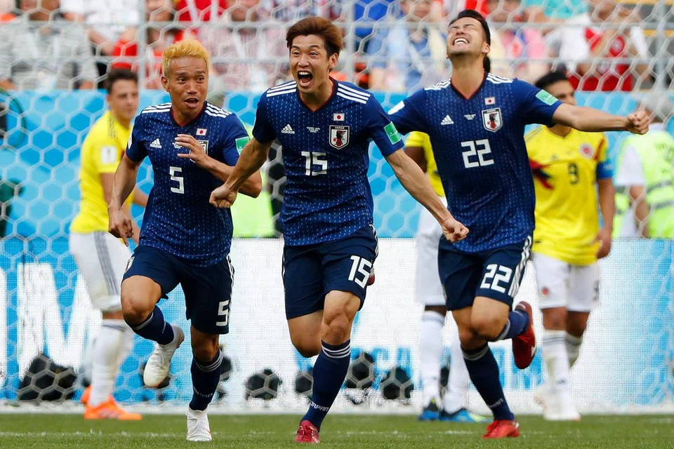 KEGEMBIRAAN I: Wira gol kemenangan Jepun, Yuya Osako (tengah), berlari kegembiraan selepas menyumbatkan gol kedua pasukannya semasa mengejutkan Colombia. - Foto AFP